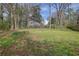 Expansive backyard with a fire pit, offering ample green space and a serene setting bordered by a wooden fence at 3532 Dial Dr, Stone Mountain, GA 30083