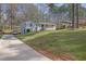 Charming exterior view featuring a well-maintained lawn, a long driveway, and a classic house design in a serene neighborhood at 3532 Dial Dr, Stone Mountain, GA 30083