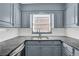 Close-up of kitchen counters with gray cabinets, subway tile backsplash, and stainless steel sink at 3532 Dial Dr, Stone Mountain, GA 30083