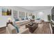 Comfortable living room featuring bright sofa with blue pillows and large windows overlooking yard at 3532 Dial Dr, Stone Mountain, GA 30083