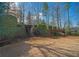 Multi-level backyard with stone stairs, retaining walls, mature trees, and green landscaping at 6195 Mountainwell Dr, Roswell, GA 30075