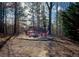 Secluded backyard fire pit area surrounded by mature trees, creating a private and tranquil outdoor space at 6195 Mountainwell Dr, Roswell, GA 30075