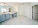 Spacious bathroom featuring double sinks, vanity area and white marble floors at 6195 Mountainwell Dr, Roswell, GA 30075