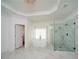 Bright bathroom featuring marble floors, glass shower, soaker tub and a stunning chandelier at 6195 Mountainwell Dr, Roswell, GA 30075