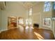 Bright living room with fireplace, chandelier, floor to ceiling windows, and kitchen access at 6195 Mountainwell Dr, Roswell, GA 30075