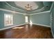 Spacious main bedroom with wood floors, tray ceiling, and natural light from multiple windows at 6195 Mountainwell Dr, Roswell, GA 30075