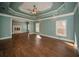 Large main bedroom features wood floors, a ceiling fan, and a fireplace in the adjacent room at 6195 Mountainwell Dr, Roswell, GA 30075
