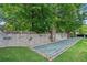 An outdoor bocce ball court is surrounded by stone walls and lush greenery at 671 Stickley Oak Way, Woodstock, GA 30189
