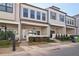 Inviting townhome exterior with gray siding, covered porch, manicured landscaping, and brick pathway at 671 Stickley Oak Way, Woodstock, GA 30189