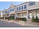 Street view of townhomes featuring gray siding, black shutters and a covered front porch with landscaping at 671 Stickley Oak Way, Woodstock, GA 30189