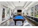 Game room features a pool table, stone fireplace, and an abundance of natural light at 671 Stickley Oak Way, Woodstock, GA 30189