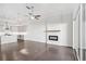Open concept living room with fireplace, wood flooring, ceiling fan, and access to the kitchen at 671 Stickley Oak Way, Woodstock, GA 30189