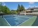 View of two outdoor tennis courts surrounded by a black fence and mature trees at 671 Stickley Oak Way, Woodstock, GA 30189