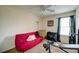 Cozy bedroom featuring a red sofa, ceiling fan, and window with natural light at 1769 Old Dogwood, Jonesboro, GA 30238