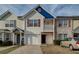 Exterior view of townhome featuring a garage, balcony, and manicured front yard with colorful shutters at 1769 Old Dogwood, Jonesboro, GA 30238