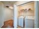 Practical laundry area with a washer, dryer, and storage shelves at 1769 Old Dogwood, Jonesboro, GA 30238