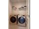 Modern laundry room with front-loading washer and dryer, and practical overhead storage shelves at 3062 Hawthorn Farm Blvd, Loganville, GA 30052