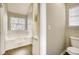 Well-lit bathroom featuring a tub and glass-block window at 2921 Russ Ln, Lithonia, GA 30058