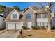 Charming two-story home featuring a stone facade, attached two-car garage, and well-maintained landscaping at 2921 Russ Ln, Lithonia, GA 30058