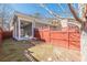 Backyard area with a covered porch, stepping stones, and a red privacy fence at 3529 S Sherwood Se Rd, Smyrna, GA 30082