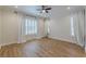 This bedroom has light hardwood floors, ceiling fan and two large windows with shutters and curtains at 3529 S Sherwood Se Rd, Smyrna, GA 30082