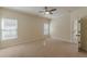 Neutral bedroom featuring a ceiling fan, plush carpeting, and an adjoining doorway at 3529 S Sherwood Se Rd, Smyrna, GA 30082