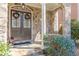 Elegant entrance with stone archway, double doors adorned with wreaths, and lush greenery at 3529 S Sherwood Se Rd, Smyrna, GA 30082