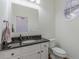 Powder room features granite countertop, white cabinets, large mirror, and oval window at 3529 S Sherwood Se Rd, Smyrna, GA 30082