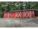 Exterior view of a red barn with white trim and double doors, offering storage and rustic charm at 616 Rich Davis Rd, Hiram, GA 30141