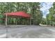 Covered carport on a paved lot has a red roof, supports, and recessed lighting at 616 Rich Davis Rd, Hiram, GA 30141