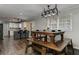 Open concept dining and kitchen area features rustic wooden table, kitchen island, hardwood floors and white cabinets at 616 Rich Davis Rd, Hiram, GA 30141
