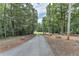 Long paved driveway lined with trees and boulders leads to the main house at 616 Rich Davis Rd, Hiram, GA 30141