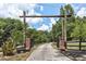 Stone and wood entry gate with mature landscaping leads to the estate at 616 Rich Davis Rd, Hiram, GA 30141