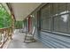 Covered front porch with rocking chairs and views of the surrounding wooded lot at 616 Rich Davis Rd, Hiram, GA 30141