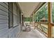 Covered front porch with rocking chairs and views of the surrounding wooded lot at 616 Rich Davis Rd, Hiram, GA 30141