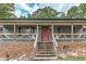 View of the house's front porch with wood railings and a brick foundation at 616 Rich Davis Rd, Hiram, GA 30141