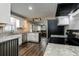 Open kitchen with stainless appliances, granite counters, white cabinets, and hardwood floors with view into dining area at 616 Rich Davis Rd, Hiram, GA 30141