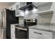 Modern kitchen features stainless steel appliances, granite countertops, white cabinets, and a black range hood at 616 Rich Davis Rd, Hiram, GA 30141
