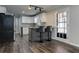 Kitchen boasts an island with bar stool seating, stainless appliances, white cabinets, granite counters, and hardwood floors at 616 Rich Davis Rd, Hiram, GA 30141