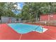 Sparkling in-ground pool surrounded by a red deck, perfect for relaxing and entertaining in a private backyard at 616 Rich Davis Rd, Hiram, GA 30141