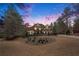 Elegant brick home shows manicured landscaping and a circular driveway at sunset at 3647 Little Spg, Stockbridge, GA 30281