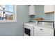 Functional laundry room with washer, dryer, storage cabinets, and a window for natural light at 4146 Mcever Park Dr, Acworth, GA 30101