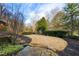A beautifully landscaped backyard with a stone patio, lush greenery, and a peaceful garden area at 4755 Columns Se Dr, Marietta, GA 30067