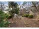 Scenic backyard with a stone pathway, mature trees, and natural landscaping creating a serene outdoor retreat at 4755 Columns Se Dr, Marietta, GA 30067