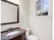 Powder room featuring a marble countertop vanity, bronze fixtures, and a window for natural light at 4755 Columns Se Dr, Marietta, GA 30067