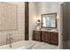 Elegant bathroom features a soaking tub and a dark wood vanity with decorative mirror at 4755 Columns Se Dr, Marietta, GA 30067