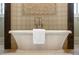 Close up of white bathtub with decorative tile and rustic wood support beams at 4755 Columns Se Dr, Marietta, GA 30067