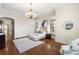 Bright bedroom boasts hardwood floors, elegant chandelier, and a doorway to the hallway at 4755 Columns Se Dr, Marietta, GA 30067