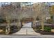 Elegant gated driveway lined with trees and stone pillars leading to the grand residence at 4755 Columns Se Dr, Marietta, GA 30067