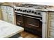 Modern stainless steel gas range with a double oven, granite countertops, and tiled floor at 4755 Columns Se Dr, Marietta, GA 30067